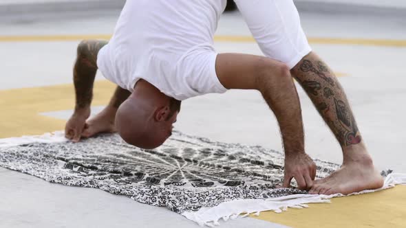 Male Posing With His Body Bent Forward Touching The Ground alt