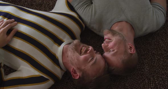 Caucasian male couple in social distancing in their sofa at home alt