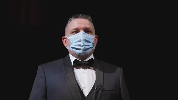 Man in elegant suit and medical mask. Portrait of an actor in protective facial mask  alt
