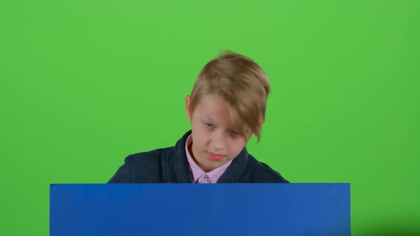 Teen Gets Up and Shows on a Board on a Green Screen alt