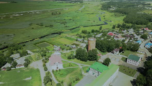 Flight Over A Provincial Town. An Ancient Tower Among The Multi Colored Roofs Of Houses alt
