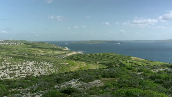 Green Plains of Gozo Island near Mediterranean Sea with Comino Island in Background alt