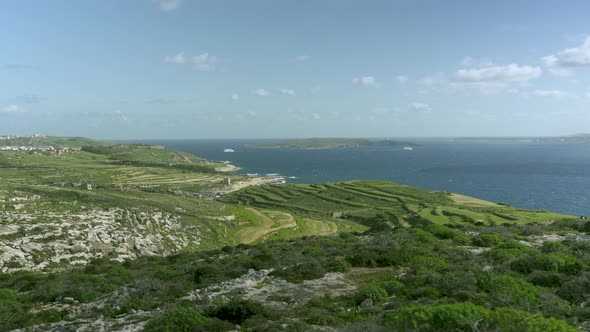 Green Plains of Gozo Island near Mediterranean Sea with Comino Island in Background