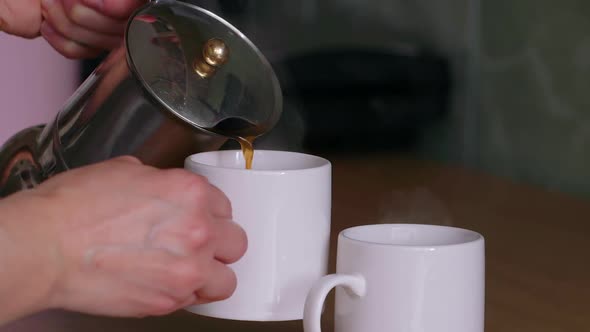 Super side view of coffee movement pouring into cup from geyser coffee machine.