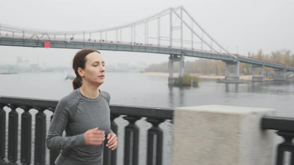 Fit attractive motivated sports woman in professional sportswear hard breathing during run training alt