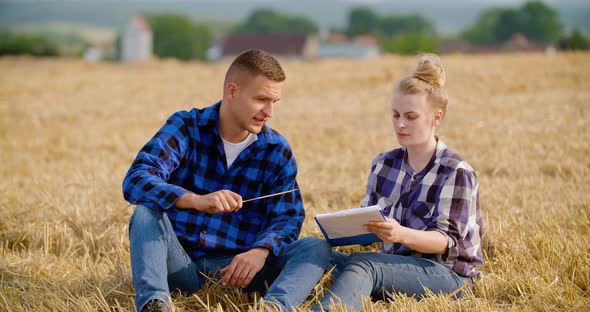 Female Farmer Discussing With Businessman On Farm alt