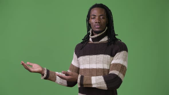 Young Handsome African Man with Dreadlocks Against Green Background alt