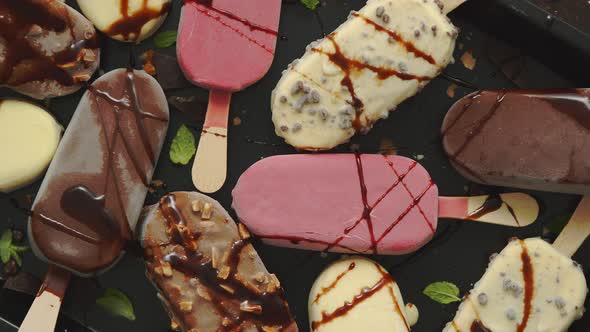 Set of Delicious White and Milk Chocolate and Strawberry Ice Cream on a Stick Served in Metal Tray