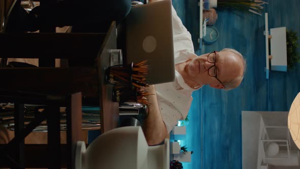 Vertical Video Senior Adult in Wheelchair Using Laptop to Find Artistic Inspiration alt