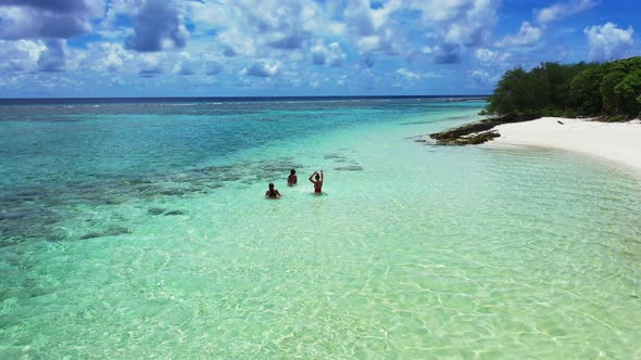 Young beauty models relaxing by the sea on the beach on clean white sand and blue background  alt
