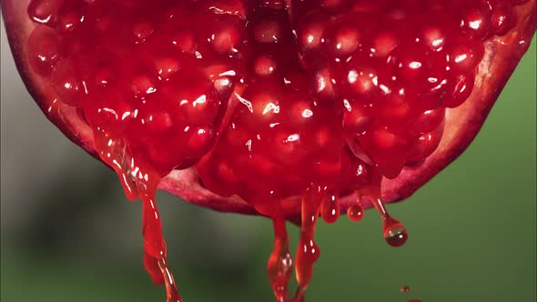 Flowing Pomegranate Juice From Half Pomegranate Macro Shot in Slow Motion alt