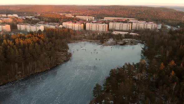 Ice Skating on Lake and Skyline Background Winter Scene Aerial