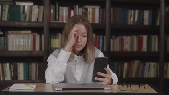 Young Schoolgirl with Short Hair in School Uniform Waving Hand Using Video Conference Call By Webcam alt