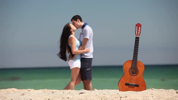 Young couple kissing on the beach by the sea