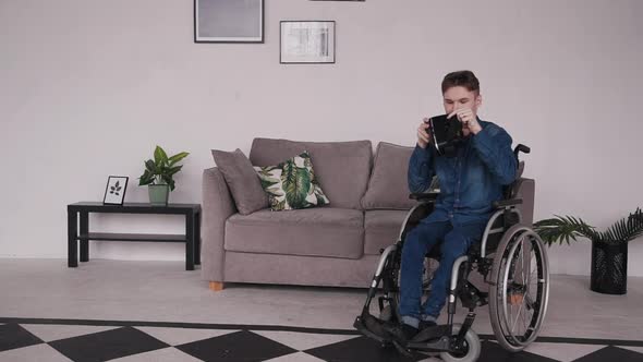 Man in Wheelchair Using Virtual Reality Glasses at Home