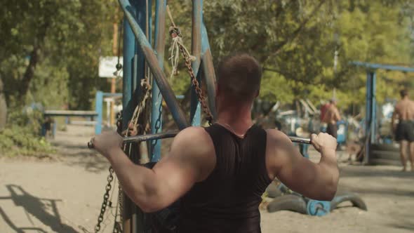 Man Strength Training Using Lat Pulldown Machine alt