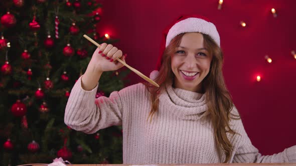 Cute Girl Singing Using Wooden Spatula Instead of Microphone on Xmas Decoration