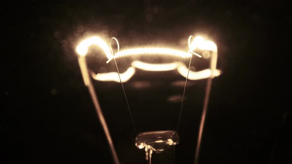 Tungsten Filament in a Glass Lamp Closeup in Slow Motion on Black Background alt