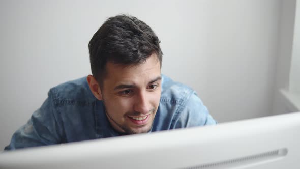 Exhausted and Frustrated Young Businessman Sitting at Office Desk He is Touching His Head alt