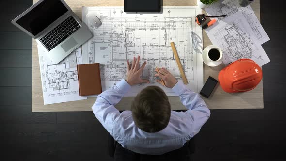 Engineer Nervously Checking Drawings Before Beginning of Building Construction alt