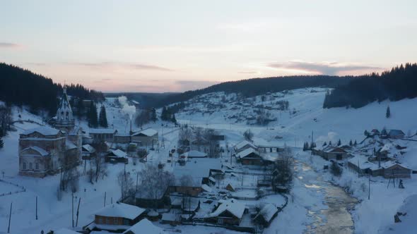 Aerial View of the Village at Sunset in Winter with Bright Sun alt