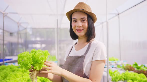 Portrait of young Caucasian farmer pretty girl working in vegetables hydroponic farm with happiness. alt