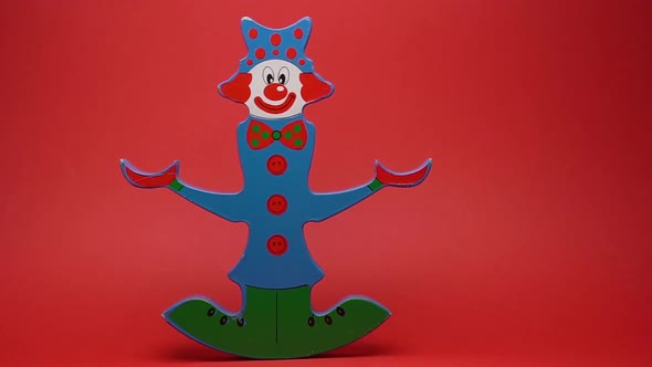 Funny wooden clown on red background