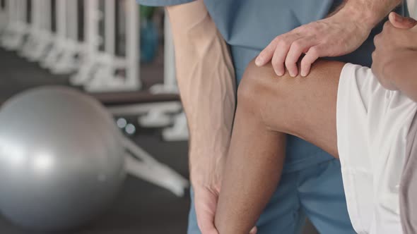 Physiotherapist Looking at Shin Bone of Patient alt