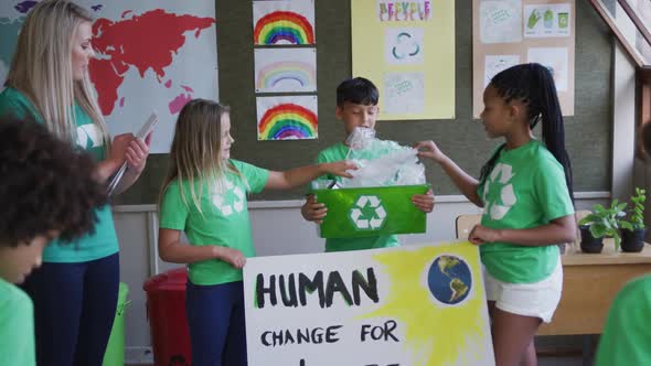 Group of kids holding climate change banner and recycle container at school alt