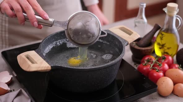 Poached Egg  Woman Puts Into a Pot of Hot Boiling Water alt