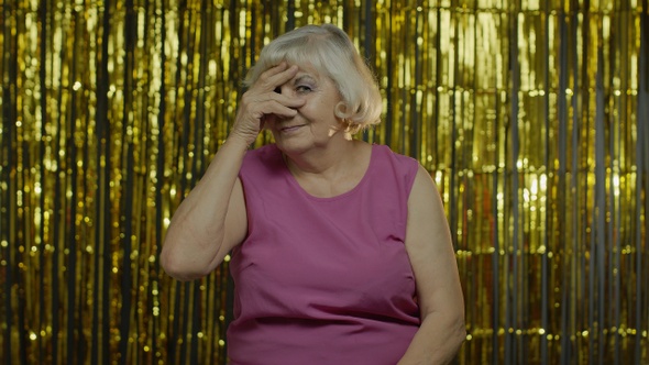 Portrait of Senior Old Woman with Closing Eyes with Hand and Spying Through Fingers, Hiding, Peeping alt