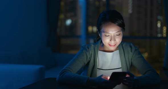 Woman look at smart phone at night