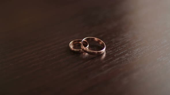 Composition of Two Wedding Rings on the Wooden Table
