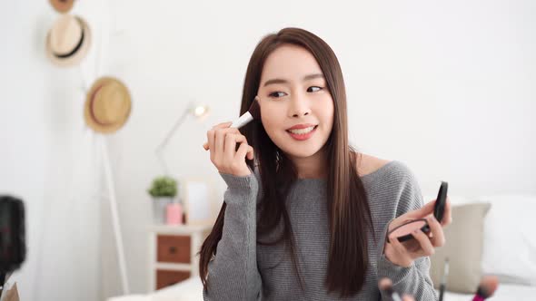 Asian woman professional beauty blogger doing cosmetic makeup tutorial online live streaming