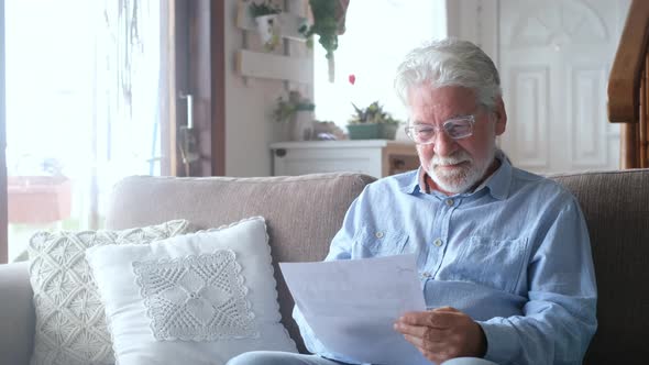 Excited elderly man celebrate health insurance deal closing looking and reading the medical results alt