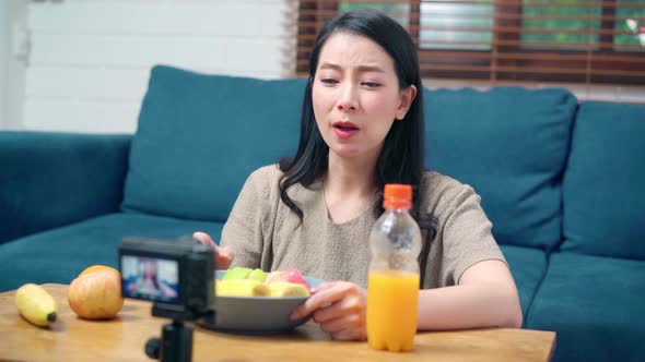Asian women using camera streaming and recording vlog video about the benefit for broadcast online. alt