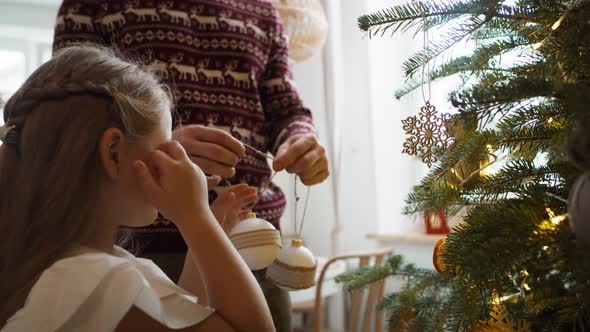 Girl with daddy decorating the Christmas tree. Shot with RED helium camera in 8K alt