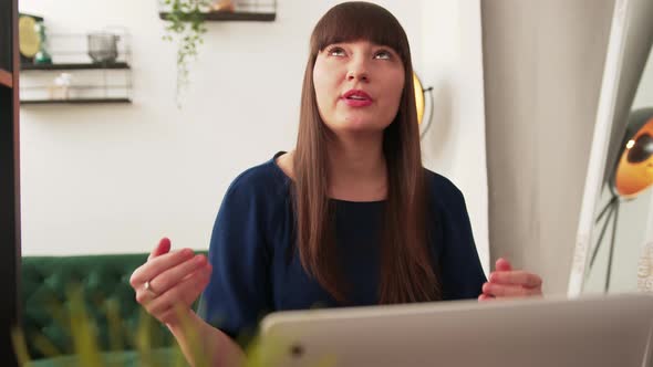 Young Caucasian Brunette Woman in Living Room Gesturing During Presentation in Online Meeting on alt