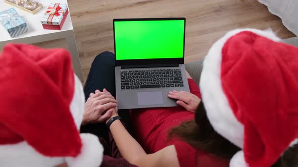 Young Couple Celebrating Christmas at Home. Enjoying Video Call by Laptop