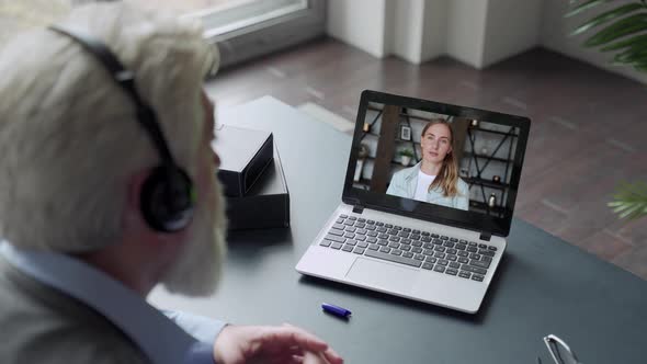 Over the Shoulder View of an Elderly Man Video Call To Daughter Using a Laptop. The Concept of alt