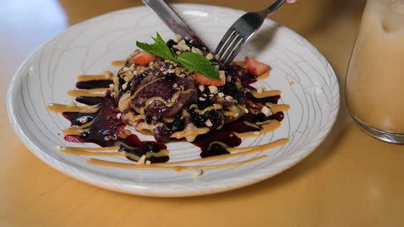 Closeup of Woman Eats Waffle with Berry Syrup alt