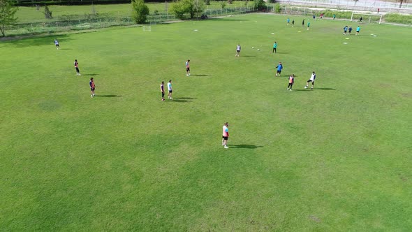 Green Soccer Field. Players Playing Football Aerial View.