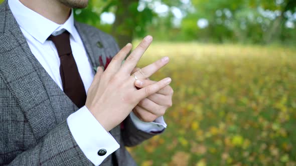 a man turns a wedding ring on his finger in close-up