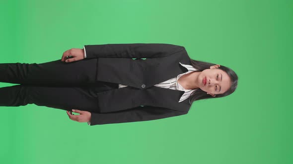 Jealous Asian Business Woman Looking In The Green Screen Studio alt
