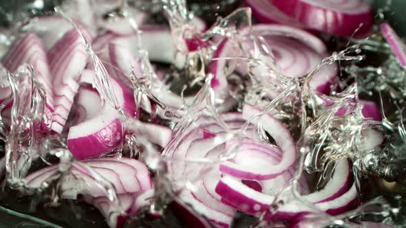 Super Slow Motion Shot of Falling Red Onion Cuts Into Oil in Pan at 1000 Fps alt