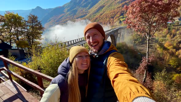 A Selfie Video of Two Tourists Woman and a Man Visiting the Magnificent Djurdjevica Bridge Over the alt