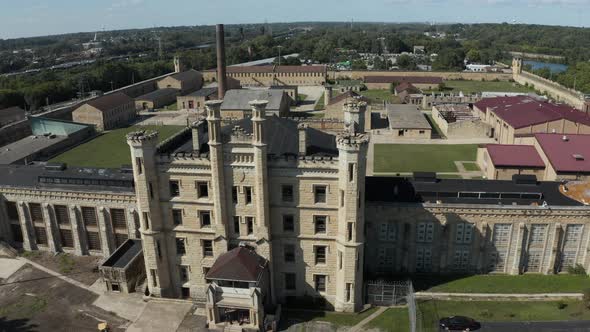 Aerial view of the old and abandoned Joliet prison or jail, a historic site. Drone flying backward t alt