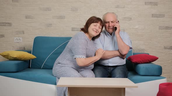 Man Is Talking on Phone with Son and His Wife Is Trying To Listen the Discussion. alt