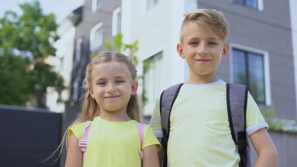 Brother Hugging Little Sister, Looking at Camera and Smiling First Day at School