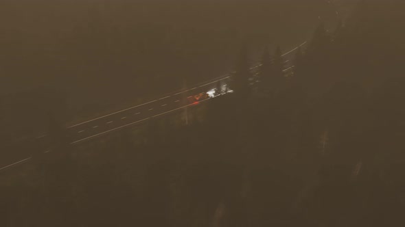 Fast car driving through a coniferous forest on a curvy road during a night. 4K alt